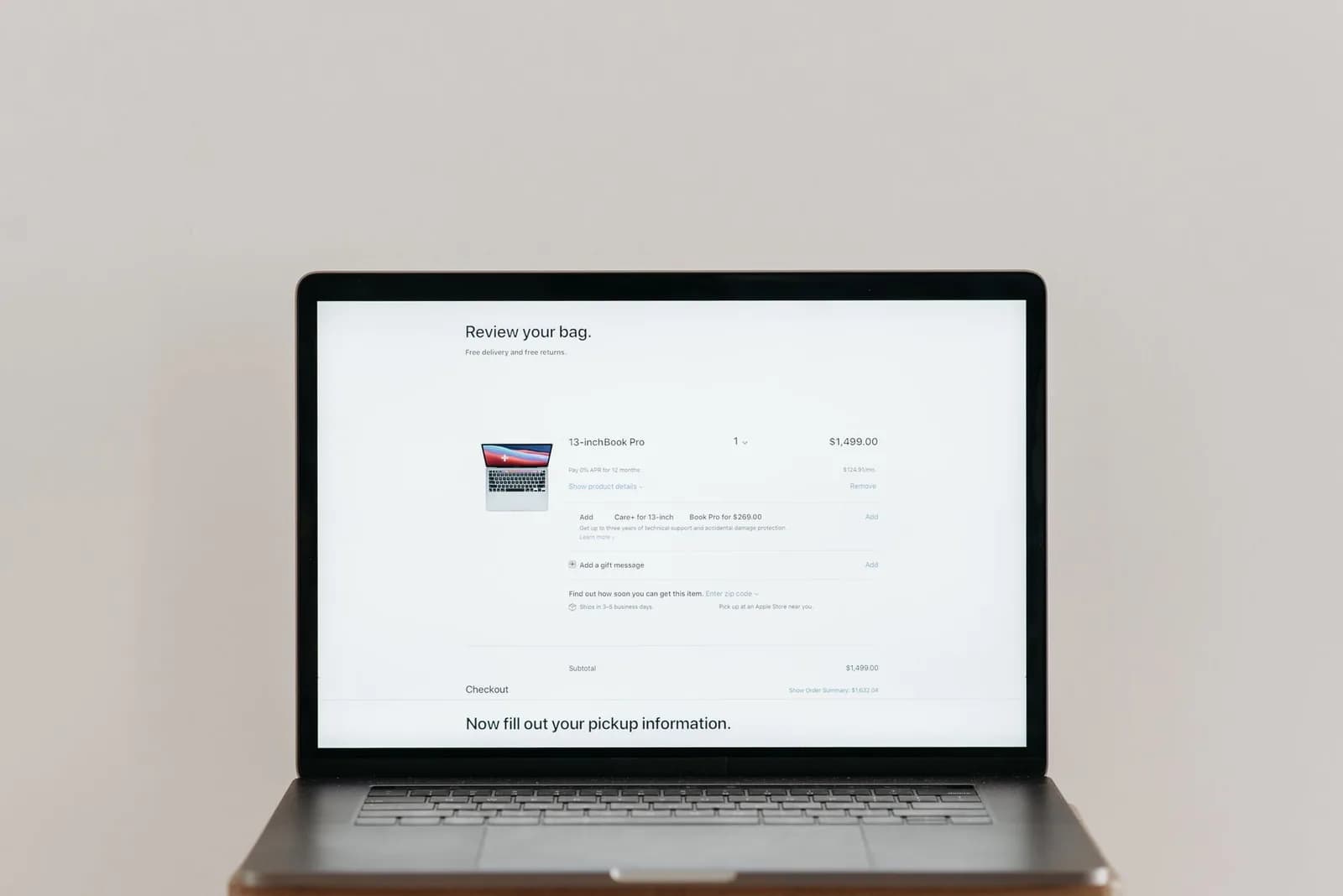 Minimalist laptop showing an online checkout screen on a white background, ideal for tech context.